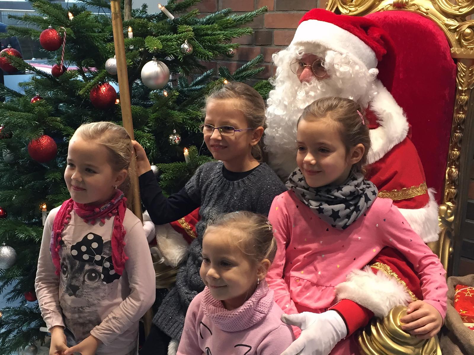 Strahlen um die Wette: Kleine Besucherinnen mit dem Weihnachtsmann.