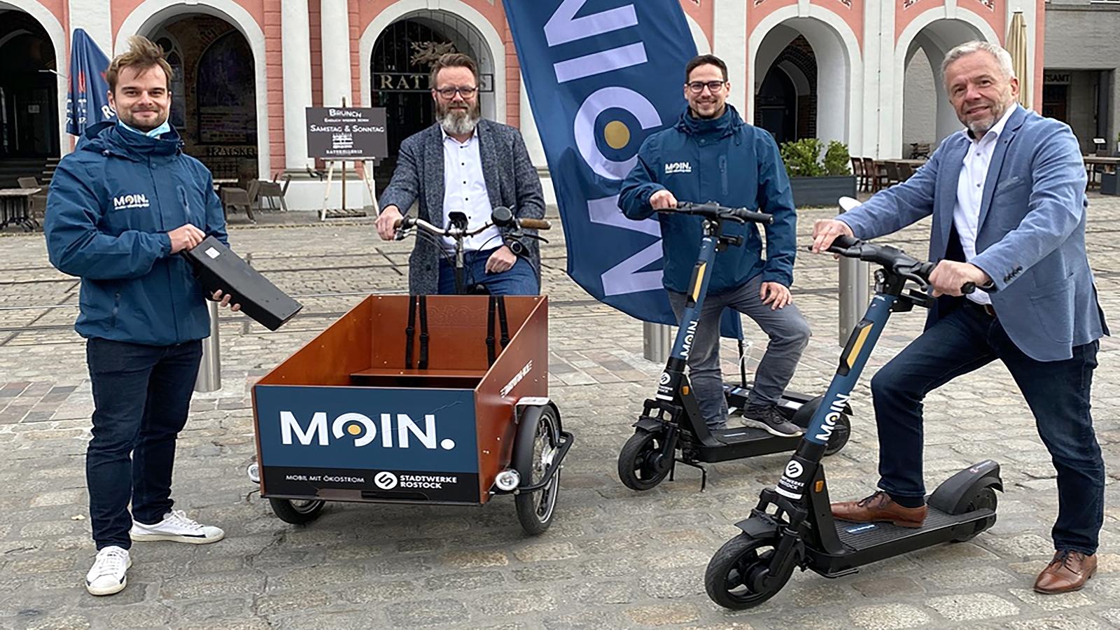 Die MOIN.-Gründer Adrian Merker (l.) und Jakob Richter (2.v.r) zusammen mit Rostocks Oberbürgermeister Claus Ruhe Madsen und Stadtwerke-Pressesprecher Thomas Schneider (r.). Foto: YourCar