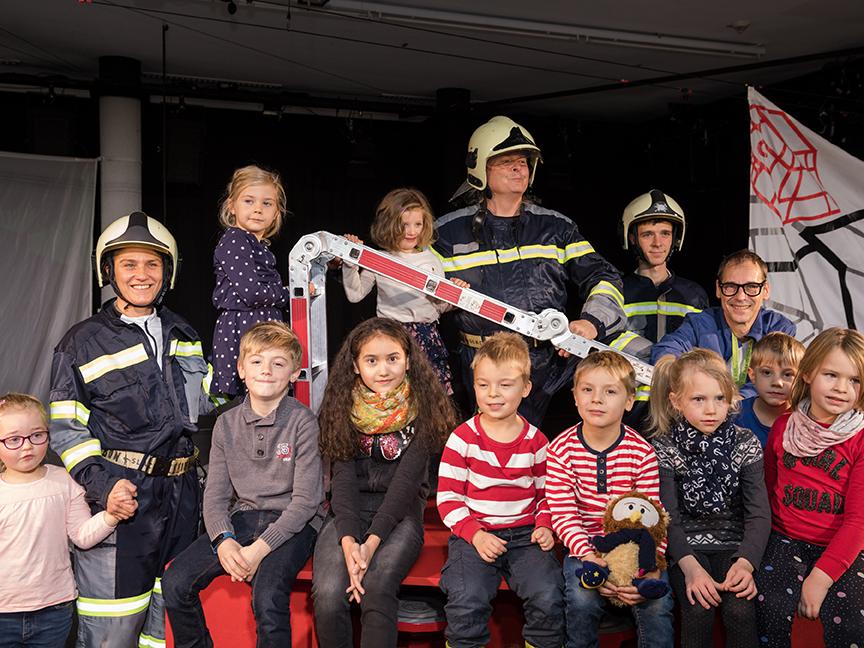 Zehn glückliche Kinder nach der Vorstellung mit den Schauspielern des Volkstheaters.