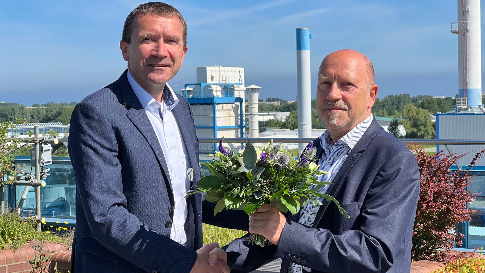 Volker Rattey überreicht Gerald Schubert einen Blumenstrauß und damit symbolisch auch die Geschäfte der Stadtwerke Rostock Netzgesellschaft mbH ab dem 1. Januar 2023.