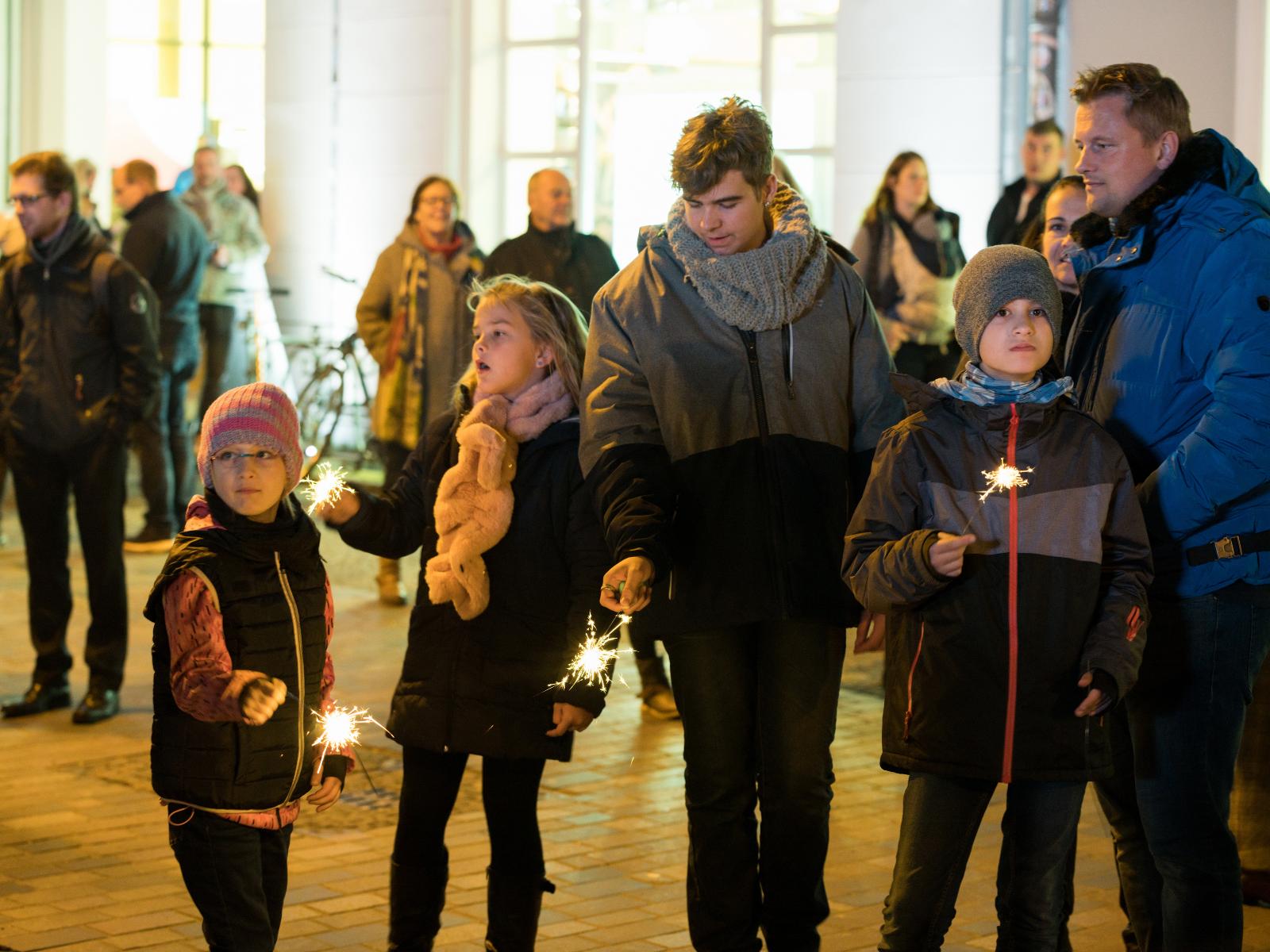 Die Kinder erhellen den Uni-Platz mit Wunderkerzen